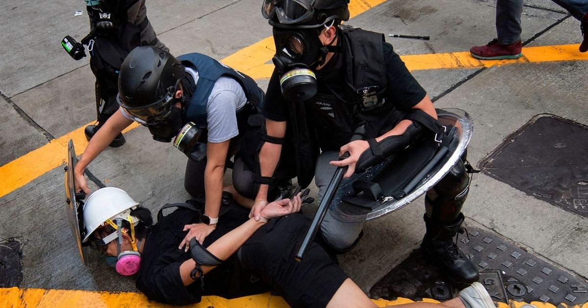 TOPSHOT - Police arrest a protester in the Wanchai area of Hong Kong on October 1, 2019, as the city observes the National Day holiday to mark the 70th anniversary of communist China's founding. - Strife-torn Hong Kong on October 1 marked the 70th anniversary of communist China's founding with defiant "Day of Grief" protests and fresh clashes with police as pro-democracy activists ignored a ban and took to the streets across the city.