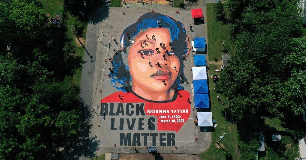 In an aerial view from a drone, a large-scale ground mural depicting Breonna Taylor with the text "Black Lives Matter" is seen being painted at Chambers Park in Annapolis, Maryland, on July 5, 2020.