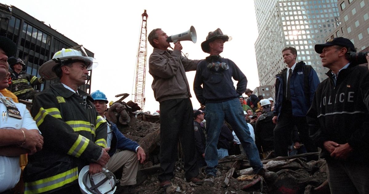 Standing atop rubble with retired New York City firefighter Bob Beckwith, President George W Bush rallies firefighters and rescue workers during an impromptu speech at the site of the collapsed World Trade Center in New York City, New York, September 14, 2001. Image courtesy National Archives.
