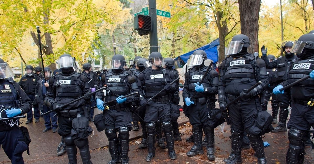 PORTLAND - NOVEMBER 13: Police in riot gear work to remove remaining protesters from the streets around the Occupy Portland encampment November 13, 2011 in Portland, Oregon. Portland police have reclaimed the two parks in which occupiers have been camping after a night of brinksmanship with protesting crowds of several thousands.