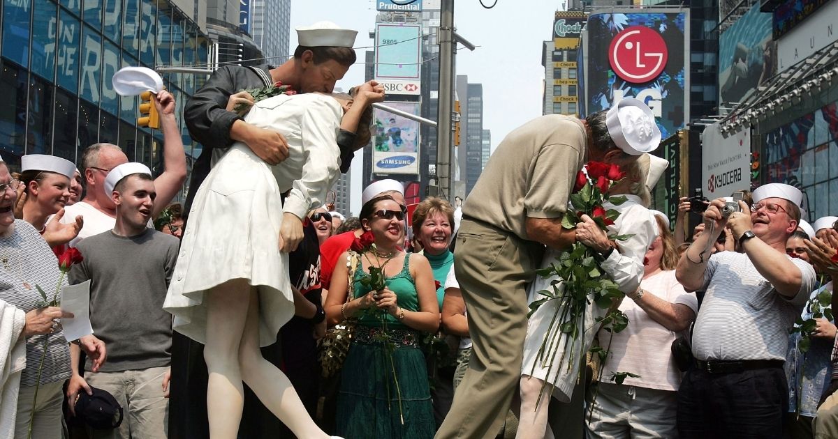 NEW YORK - AUGUST 14: Carl Muscarello and Edith Shain, who claim to be the nurse and sailor in the famous photograph taken on V-J Day, kiss next to a sculpture based on the photograph in Times Square to commemorate the 60th anniversary of the end of World War II August 14, 2005 in New York City. Alfred Eisenstaedt took the famous photograph in Times Square but did not note the names of the people in the picture.