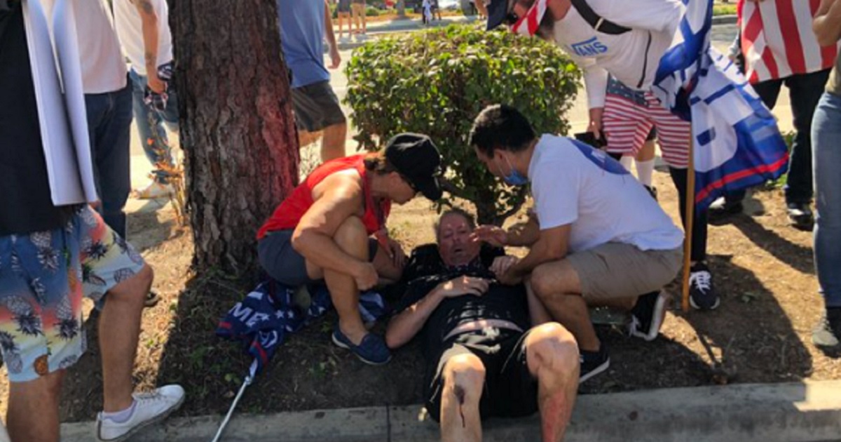 Fellow demonstrators tend to a man injured Saturday when a vehicle drove into a crowd of supporters of President Donald Trump in Yorba Linda, California.