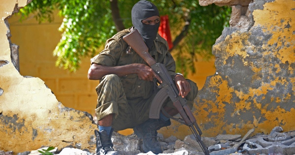 A Somali soldier stands guard at a site where al-Shabab militants carried out a suicide attack against a military intelligence base in Mogadishu on June 21, 2015.