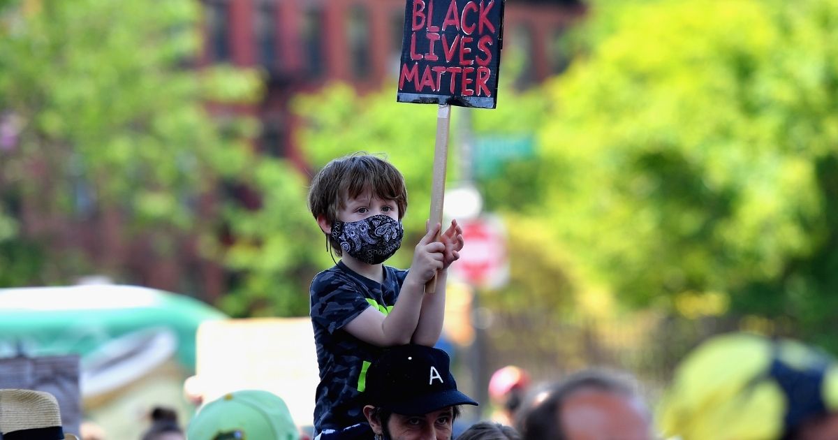 Families participate in a children's march in solidarity with the Black Lives Matter movement on June 9, 2020, in the Brooklyn borough of New York City.