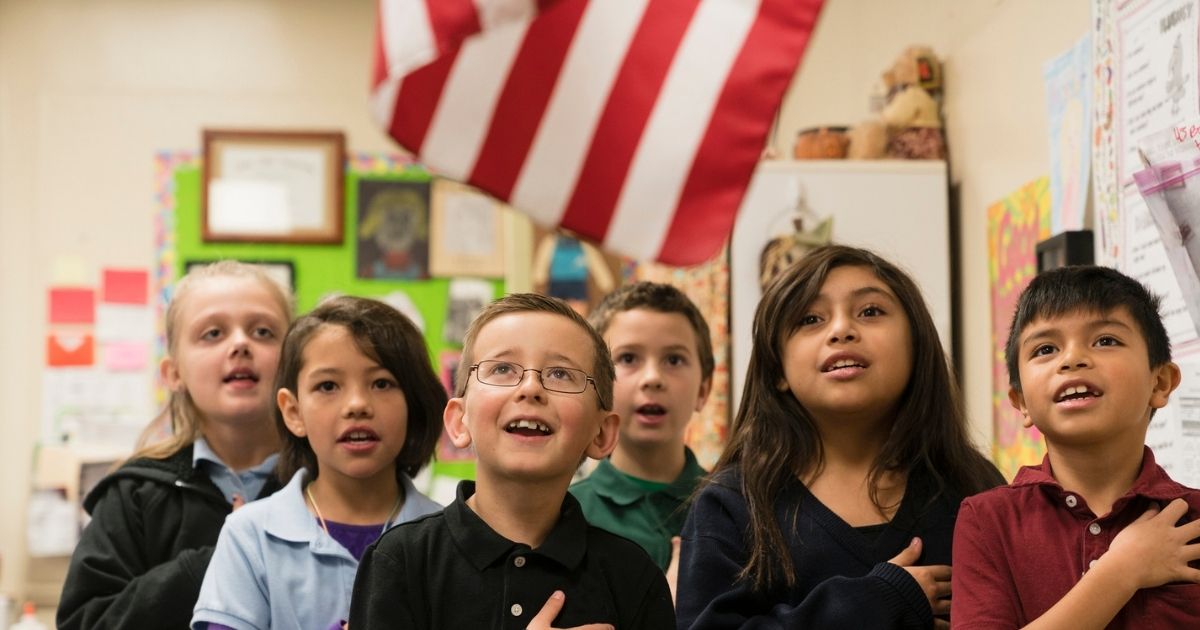 Children say the Pledge of Allegiance in this stock image.