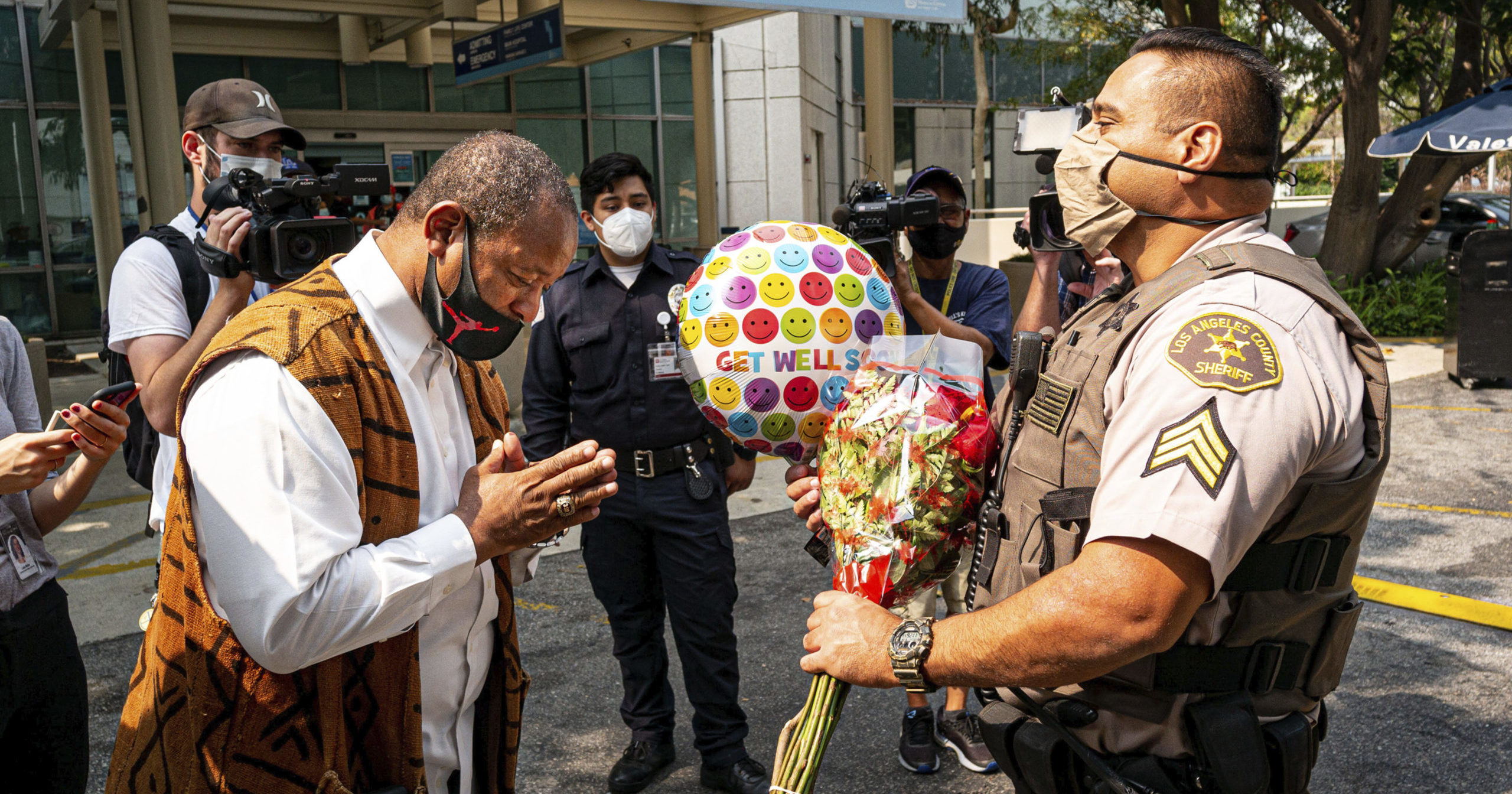 Najee Ali of Project Islamic Hope presents Sgt. Larry Villareal of the Los Angeles County Sheriff's Department flowers for deputies recovering at St. Francis Medical Center in Lynwood, California, on Sept. 14, 2020. The two deputies were shot Sept. 12 while in their patrol vehicle in an ambush attack.