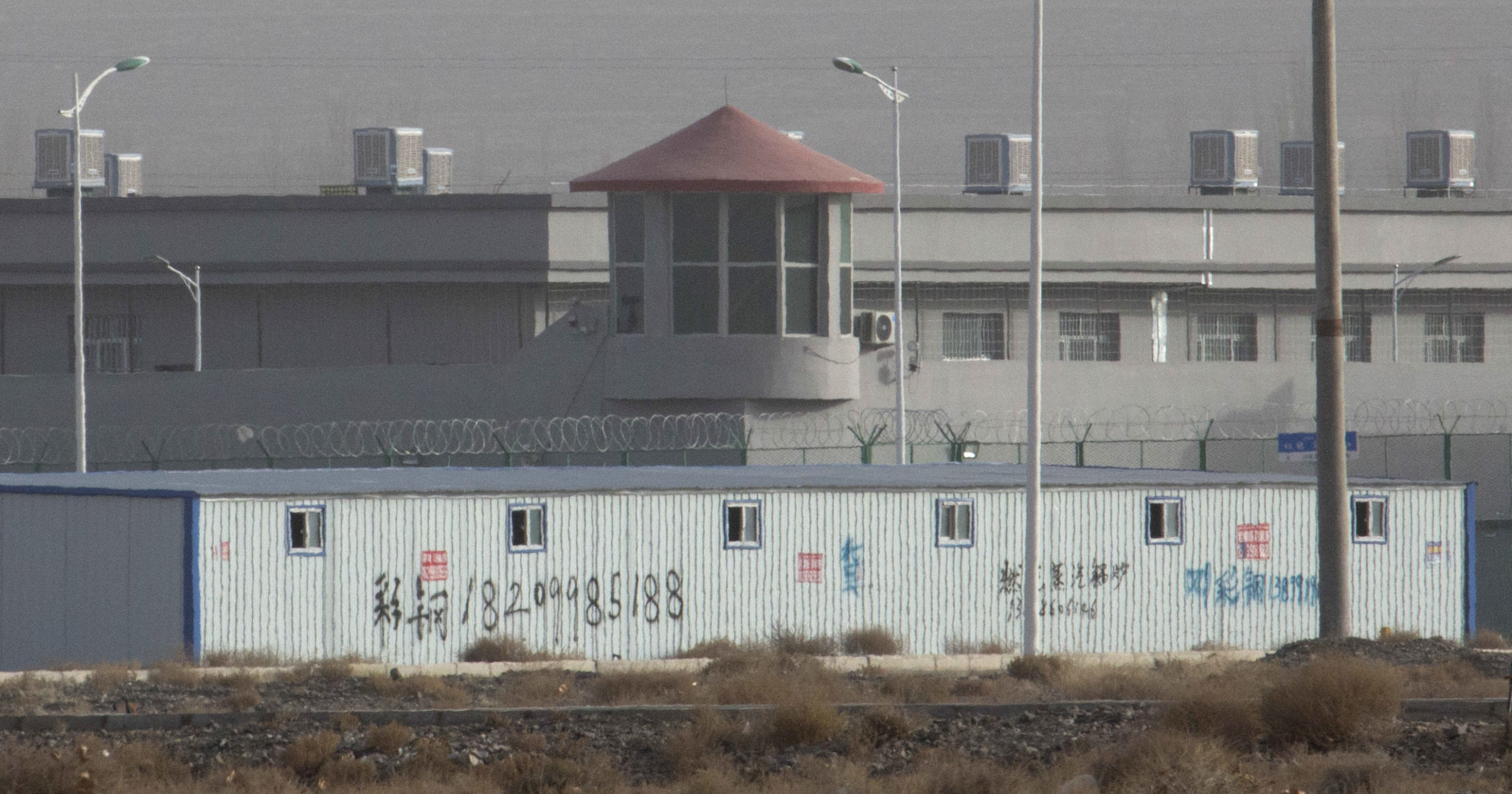 In this Dec. 3, 2018, file photo, a guard tower and barbed wire fences are seen around a facility in the Kunshan Industrial Park in western China's Xinjiang region. An Australian think tank says China appears to be expanding its network of secret detention centers in Xinjiang, where Muslim minorities are targeted in a forced assimilation campaign.