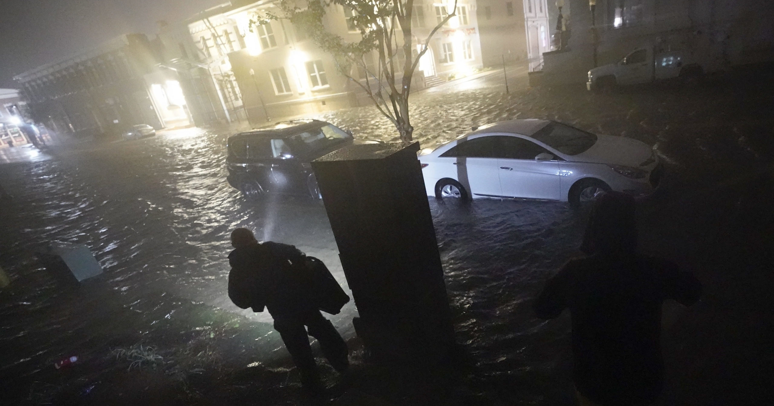 People use flashlights as they walk on flooded streets on Sept. 16, 2020, in Pensacola, Florida. Hurricane Sally made landfall near Gulf Shores, Alabama, as a Category 2 storm, dumping torrential rain that forecasters said would cause dangerous flooding from the Florida Panhandle to Mississippi and well inland in the days ahead.