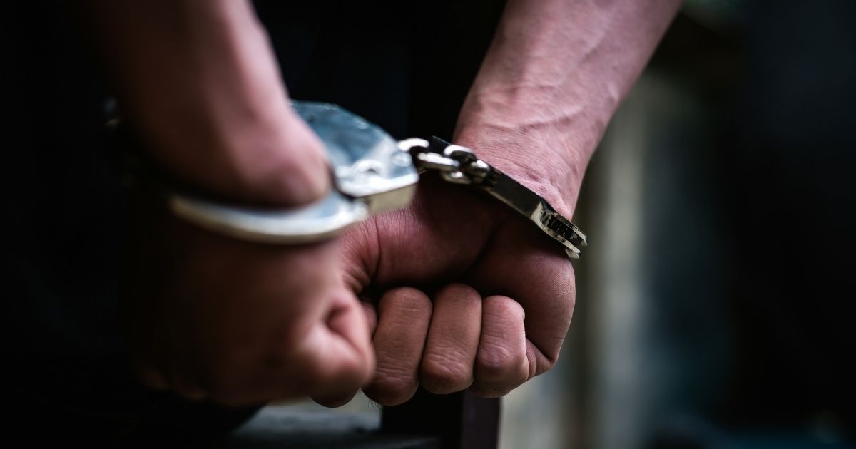 A man in handcuffs is seen in this stock image.