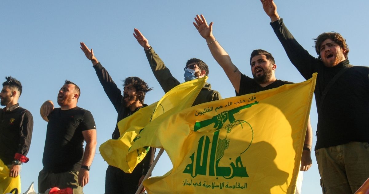 Supporters of the Shiite movement Hezbollah perform a salute in southern Lebanese on the border with Israel on May 25, 2020.