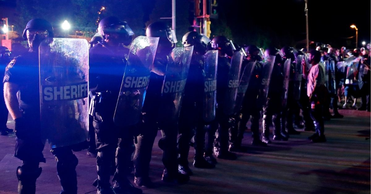 Protesters face off with police outside the county courthouse during protests against the shooting of Jacob Blake in Kenosha, Wisconsin, on Aug. 25, 2020.