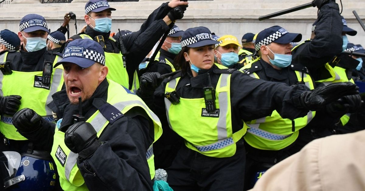 Police move in to disperse protesters in Trafalgar Square in London on Sept. 26, 2020.