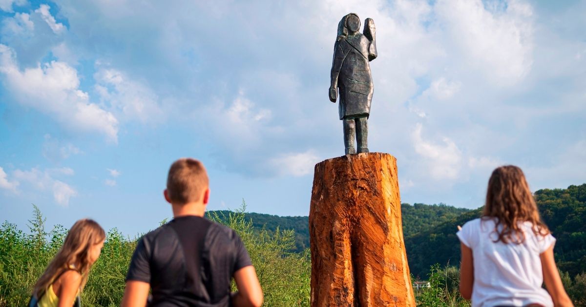 Children look at a bronze statue depicting US First Lady Melania Trump after its unveiling in a field near Trump's hometown of Sevnica, Slovenia, on Sept. 15, 2020. The statue is a replica of an original wooden statue which was burned by unknown perpetrators on July 5, 2020.