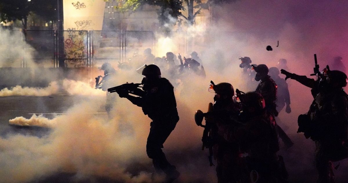 Federal officers deploy tear gas while dispersing a crowd of about a thousand protesters in front of the Mark O. Hatfield US Courthouse on July 24, 2020, in Portland, Oregon.