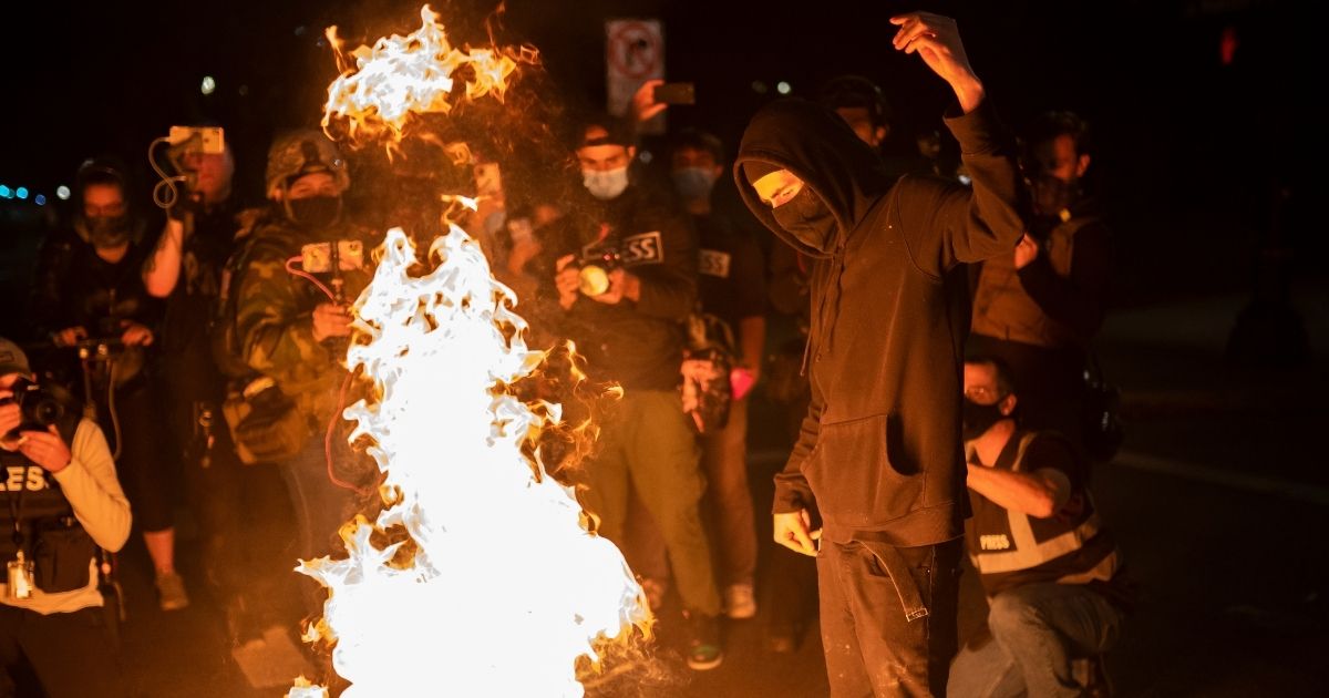 A protester burns an American flag on Sept. 26, 2020, in Portland, Oregon.