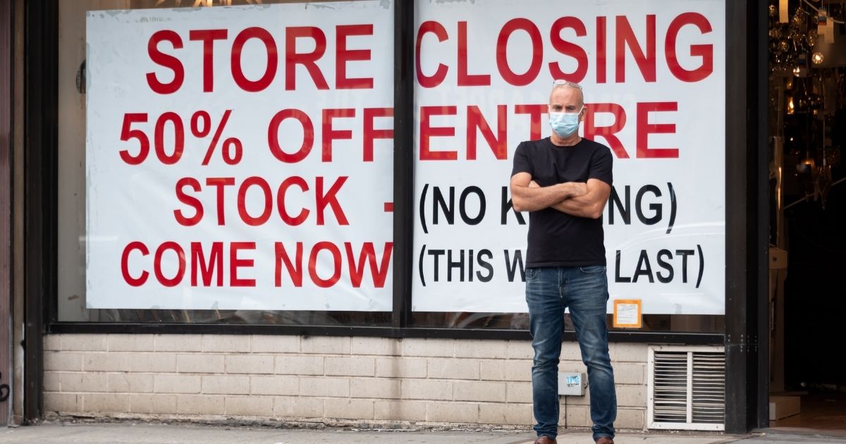A man stands outside a closing retail store on Sept. 13, 2020, in New York City.