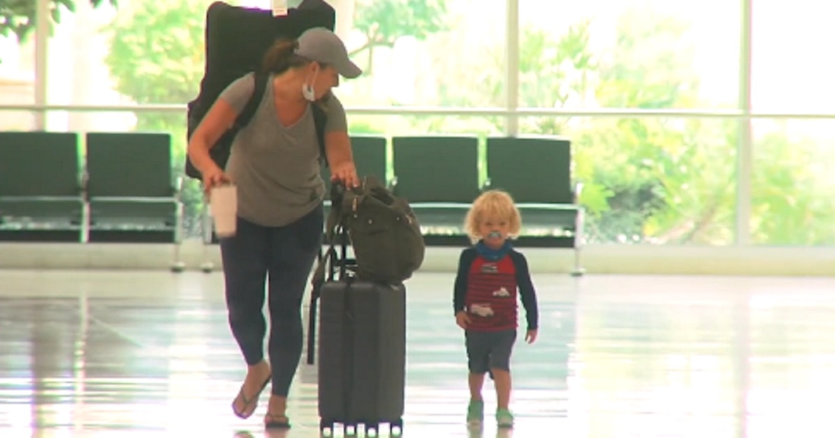 Jodi Degyansky and her 2-year-old son pictured walking in an airport.