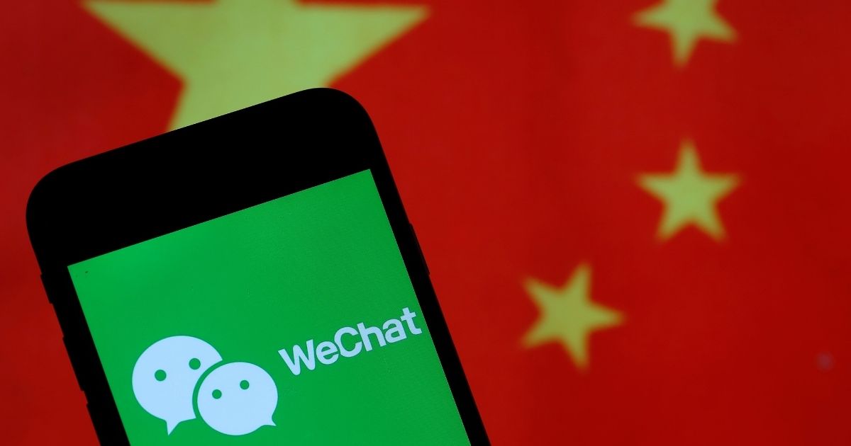 The logo of the Chinese app WeChat is displayed on the screen of a smartphone in front of a Chinese flag on Sept. 18, 2020, in Paris.
