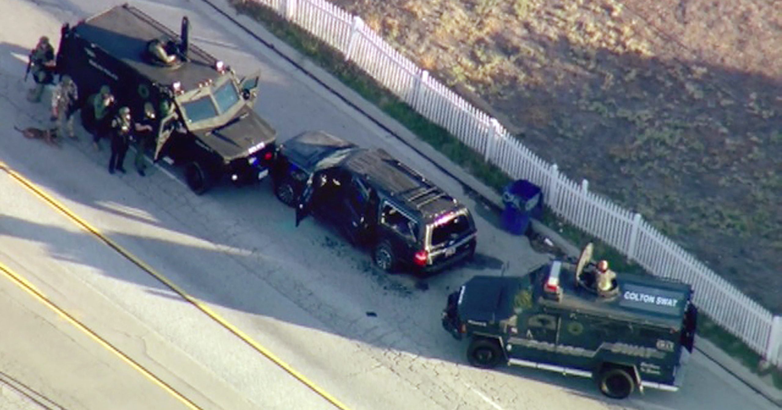 In this Dec. 2, 2015, file photo, armored vehicles surround an SUV following a shootout in San Bernardino, California.