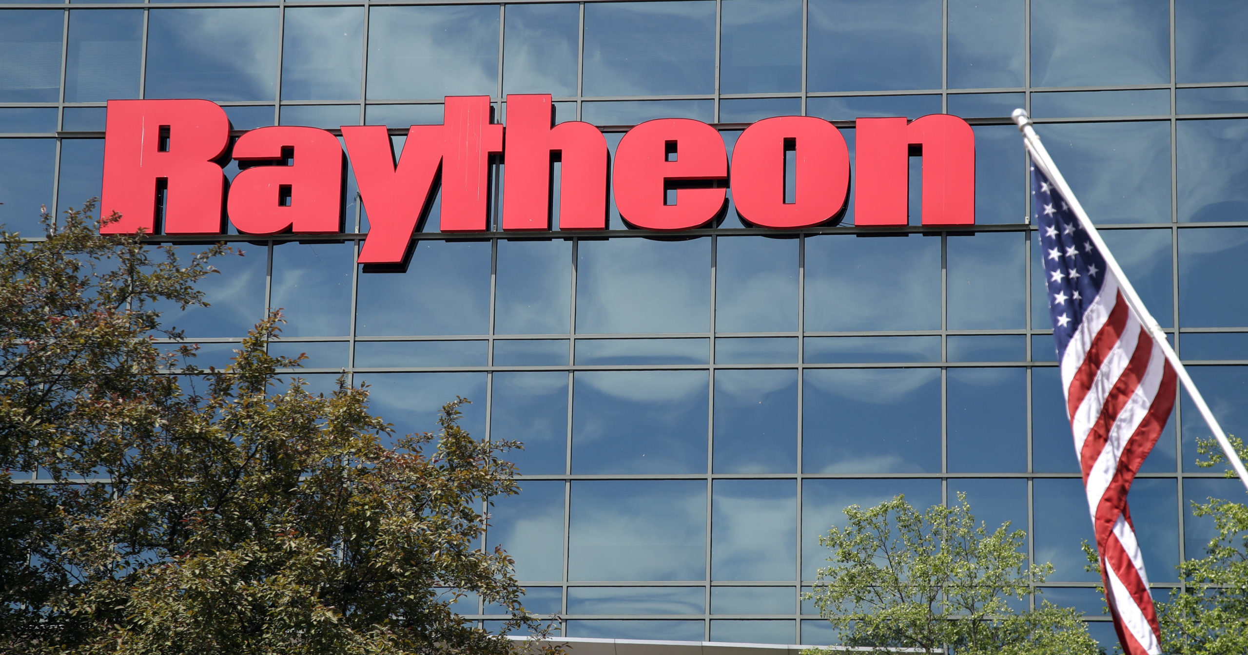 In this June 10, 2019, file photo, an American flag flies in front of Raytheon's Integrated Defense Systems facility in Woburn, Massachusetts.