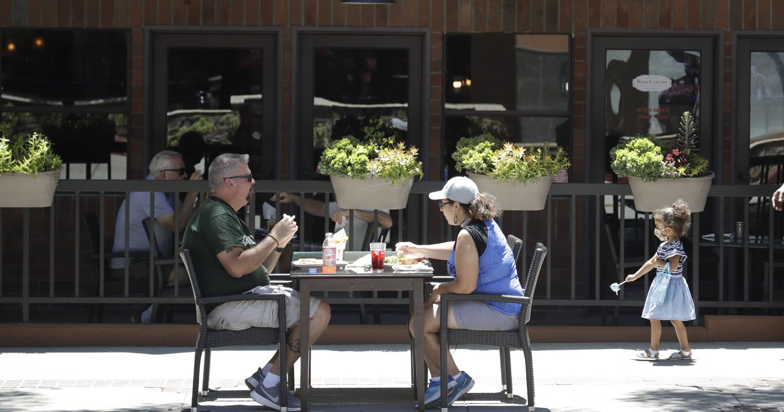 Patrons eat at a restaurant table set up on a sidewalk in Burbank, California, on July 18.