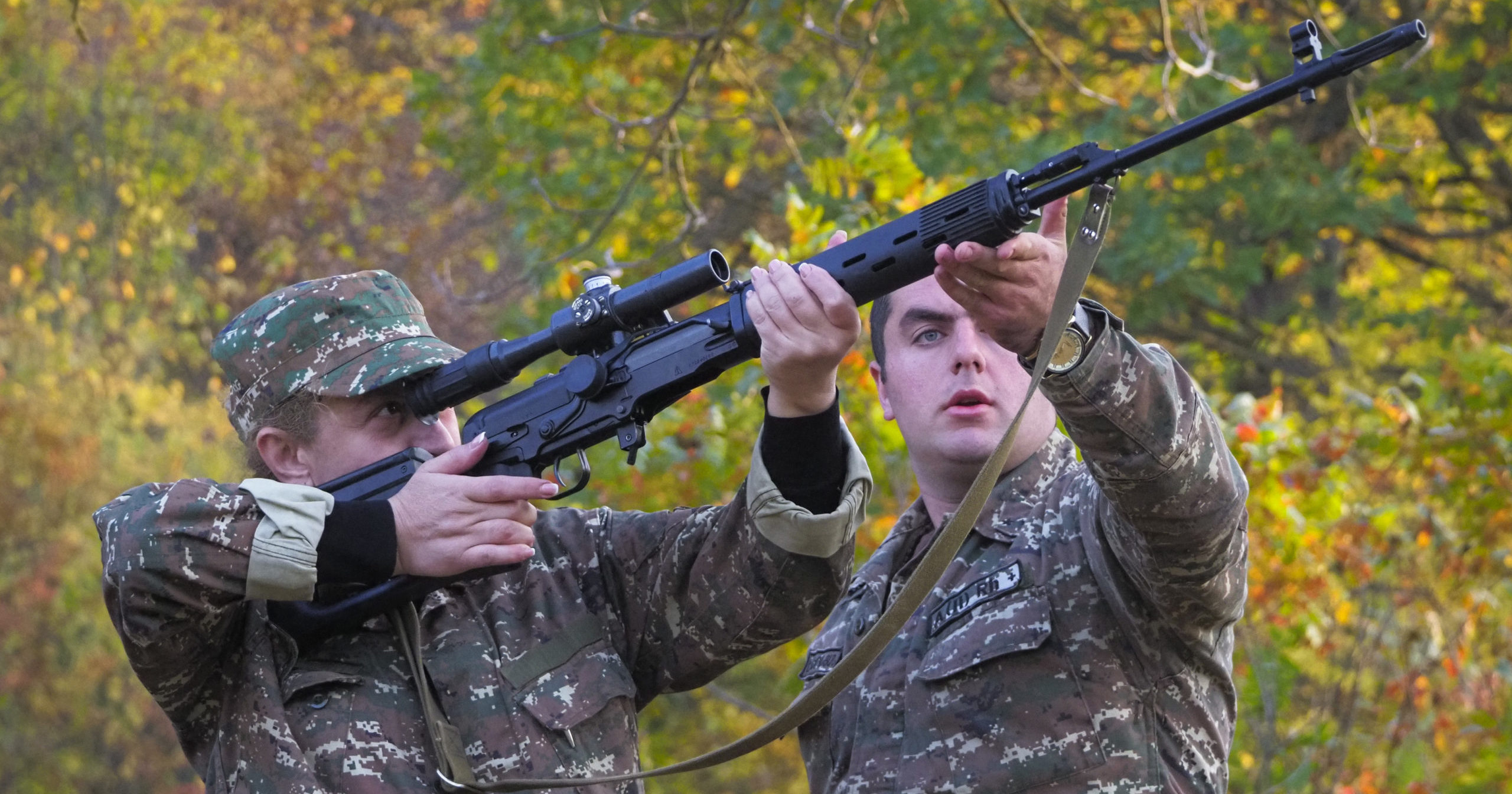 An instructor helps a volunteer soldier practice with a sniper rifle at a military base during a conflict in the separatist region of Nagorno-Karabakh on Oct. 27, 2020.