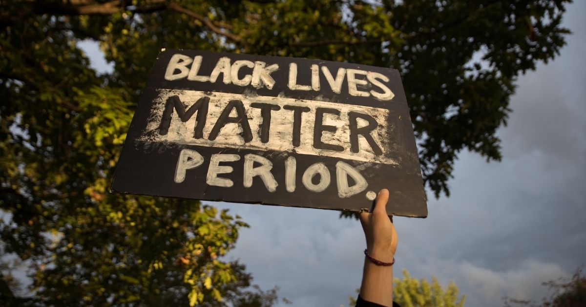 A protester holds a "Black Lives Matter" sign outside the debate center during the first presidential debate at Case Western Reserve University in Cleveland on Tuesday.