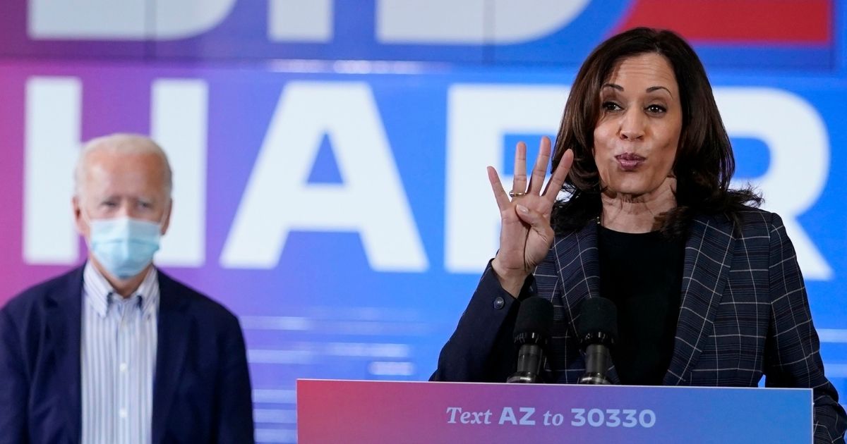 Democratic presidential candidate former Vice President Joe Biden listens while his running mate, California Sen. Kamala Harris, speaks during a campaign event at the Carpenters Local Union 1912 in Phoenix on Oct. 8, 2020.