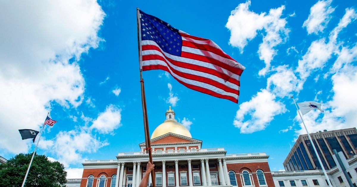 An American flag is seen during a protest outside the Massachusetts State House in Boston on Aug. 30, 2020.