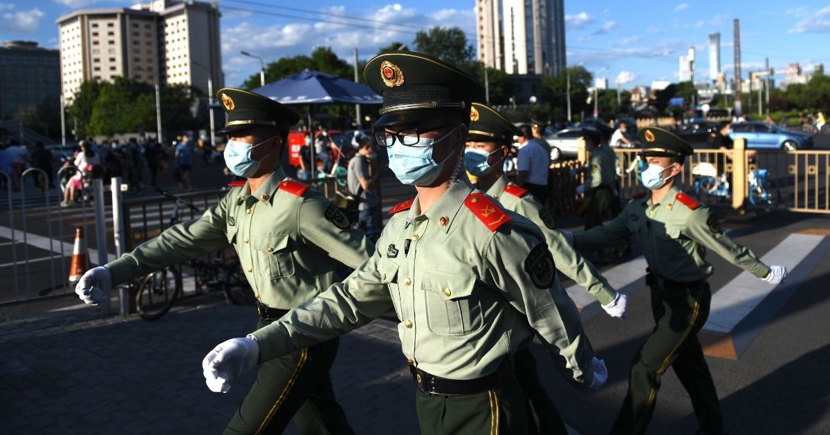 Paramilitary police officers patrol along a street after the closing session of the Chinese People's Political Consultative Conference in Beijing on May 27, 2020.