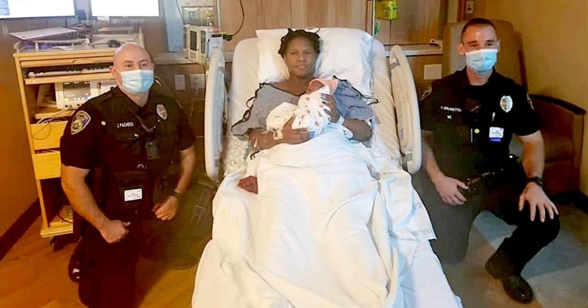 Two Stockton Police officers with the mother whose baby was delivered in the PD's parking lot.