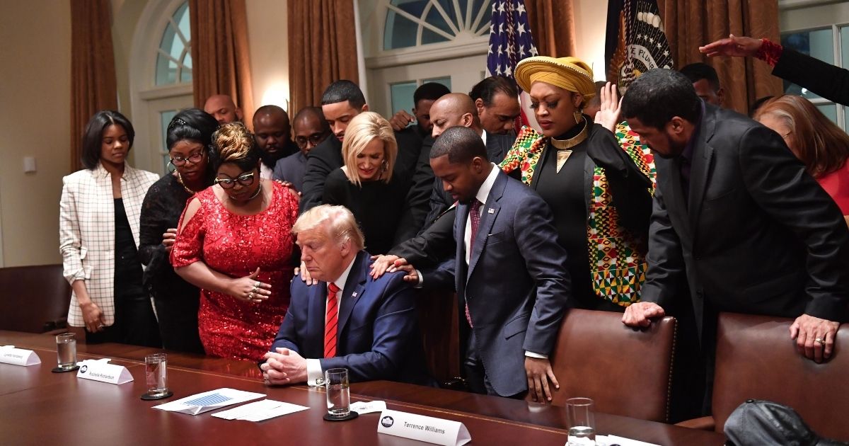 President Donald Trump, center, stands in a prayer circle with African-American leaders in the Cabinet Room of the White House in Washington, D.C., on Feb. 27, 2020.