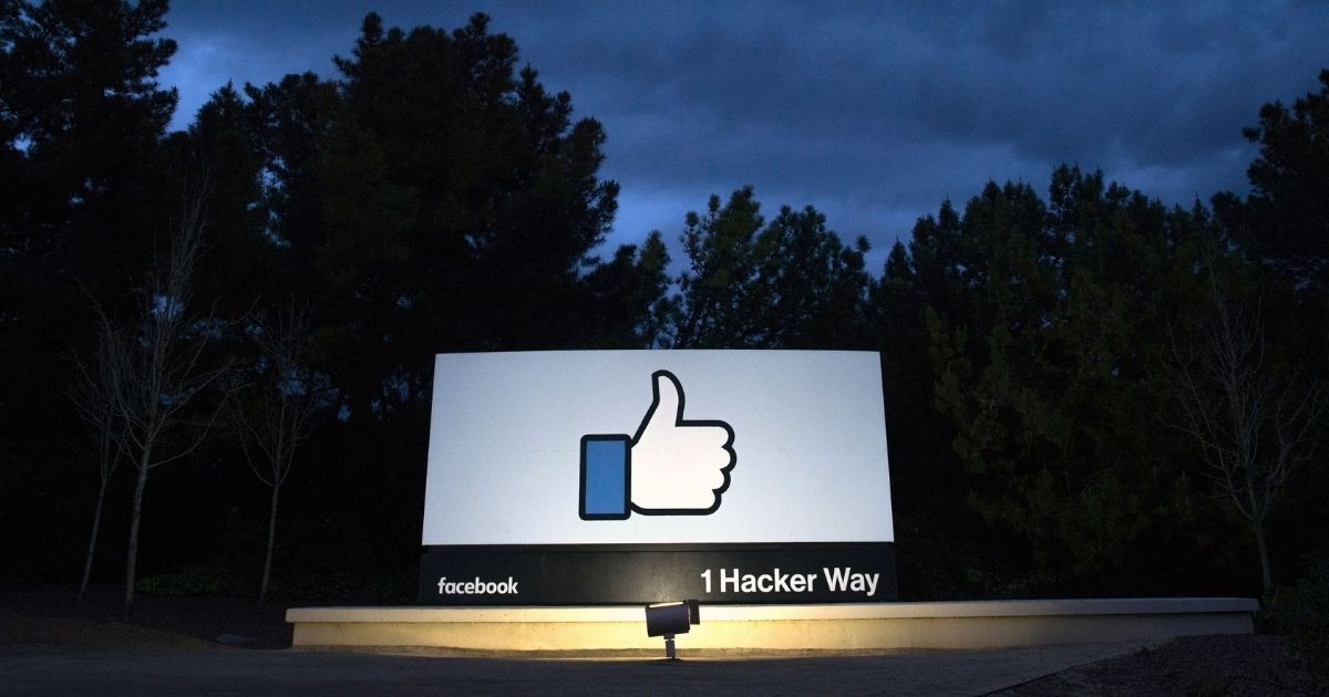 A lit sign is seen at the entrance to Facebook's corporate headquarters location in Menlo Park, California, on March 21, 2018.
