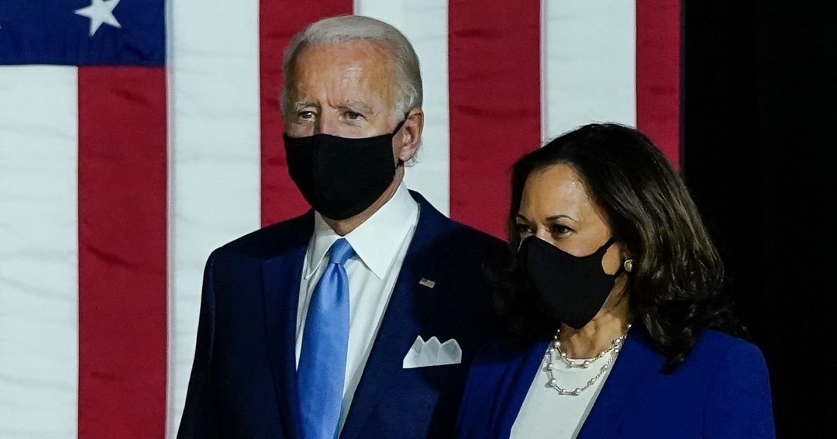 Democratic presidential nominee former Vice President Joe Biden, left, and his running mate, California Sen. Kamala Harris, arrive to deliver remarks at the Alexis Dupont High School on Aug. 12, 2020, in Wilmington, Delaware.
