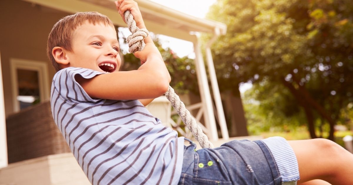A boy plays on a rope swing in the stock image above.