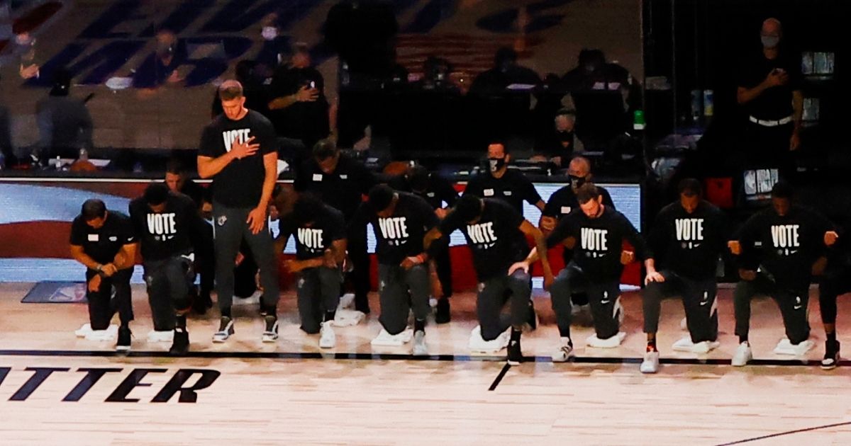 Members of the Miami Heat, with the exception of Meyers Leonard, kneel during the national anthem prior to Game 1 of the 2020 NBA Finals at AdventHealth Arena at the ESPN Wide World of Sports Complex on Wednesday in Lake Buena Vista, Florida.