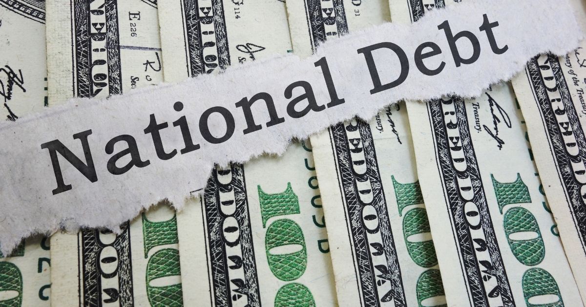 A photo of bills representing the national debt is pictured above.