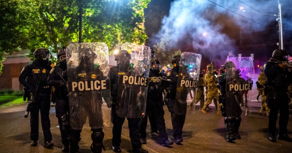 Federal officers disperse a crowd of protesters on Tuesday in Portland, Oregon.