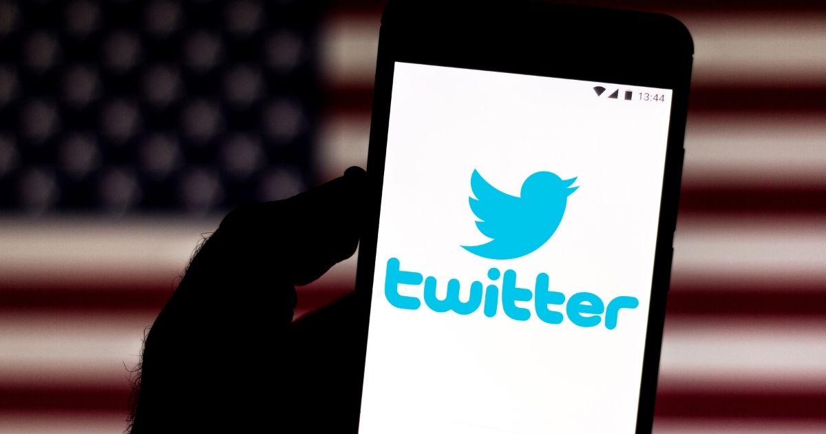 The Twitter logo is displayed on a smartphone in the stock image above.