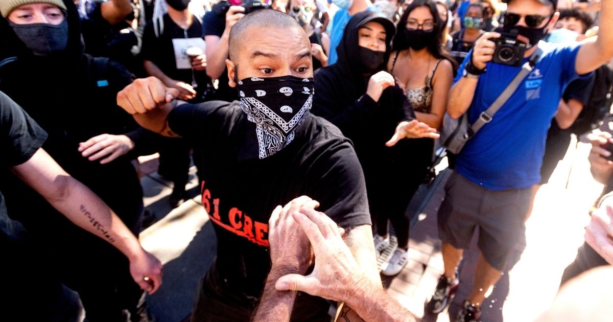 An attacker pulls back to punch an organizer of a free speech rally Saturday in San Francisco.