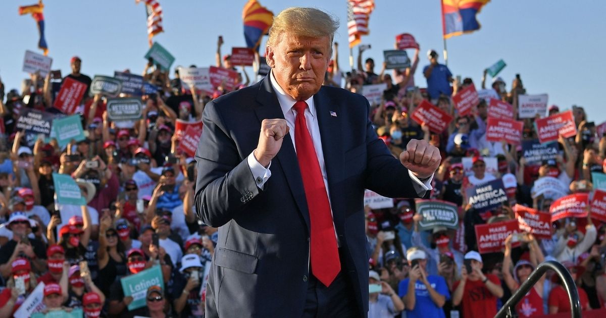 US President Donald Trump dances as he leaves a rally at Tucson International Airport in Tucson, Arizona on October 19, 2020. - US President Donald Trump went after top government scientist Anthony Fauci in a call with campaign staffers on October 19, 2020, suggesting the hugely respected and popular doctor was an "idiot."