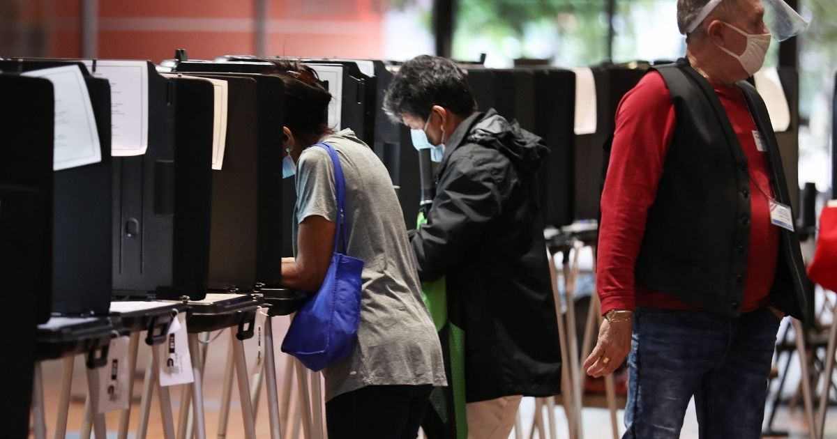 Voters fill out their ballots as they vote at the Stephen P. Clark Government Center polling station on Oct. 21, 2020, in Miami.