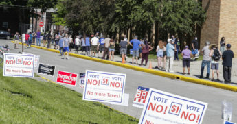 In this June 2, 2020, file photo, voters wait in a line outside Broad Ripple High School to vote in the Indiana primary in Indianapolis.