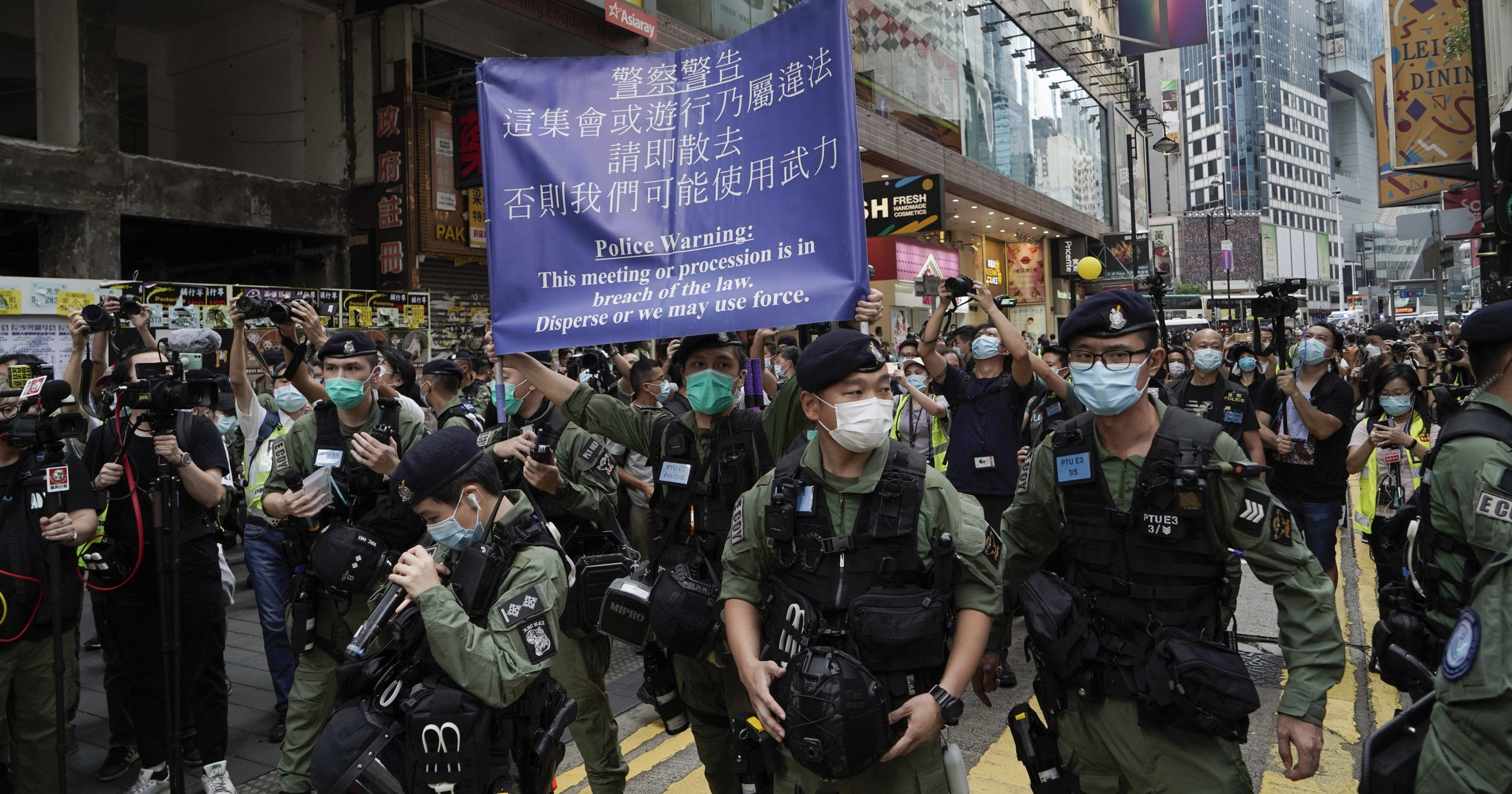 Police officers display a warning banner on China's National Day in Hong Kong on Oct. 1, 2020.