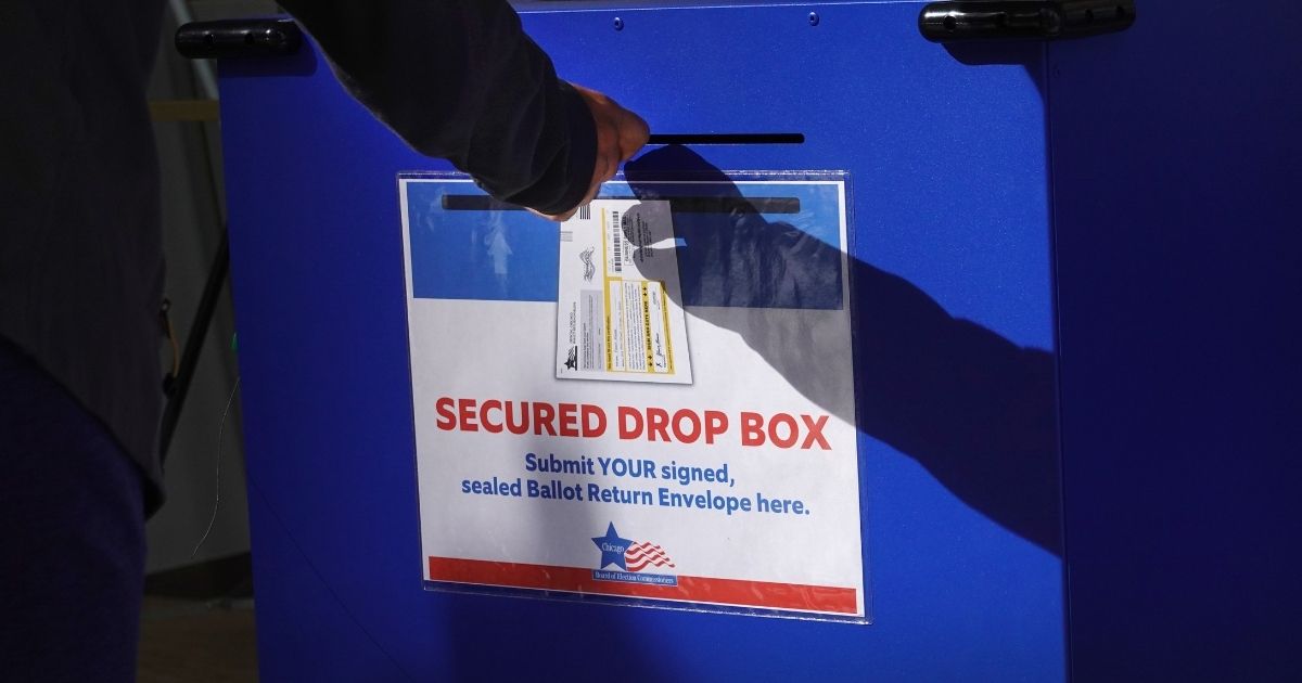 A voter drops off a mail ballot in a drop box on Oct. 2, 2020, in Chicago.