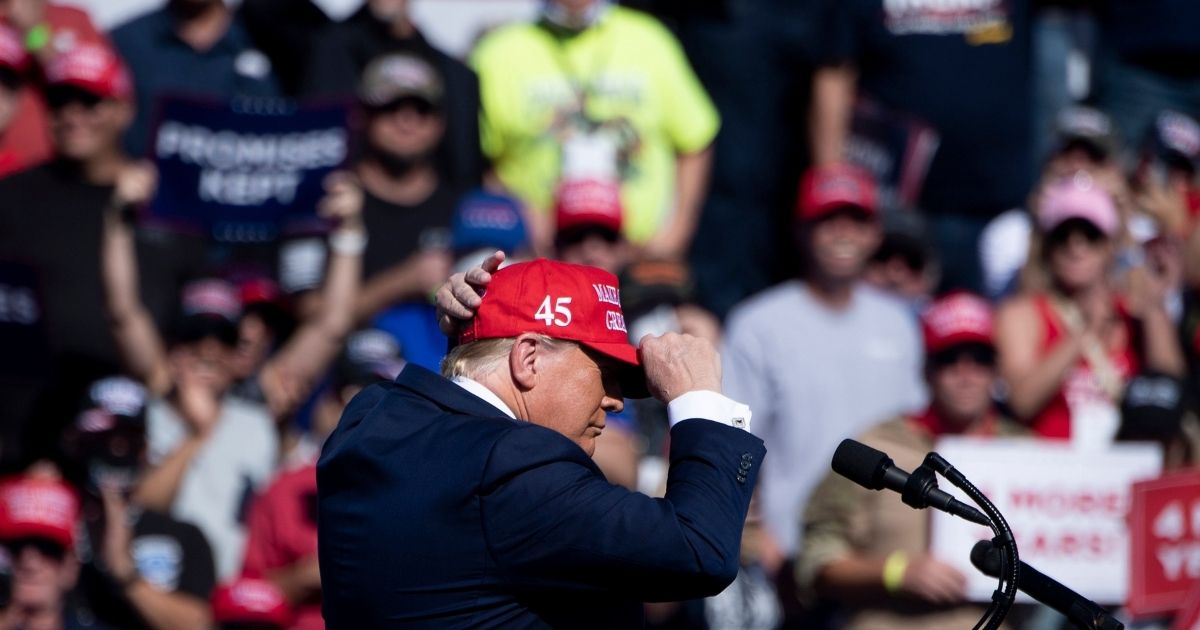 President Donald Trump puts on a hat during a rally on Oct. 28, 2020, in Bullhead City, Arizona.