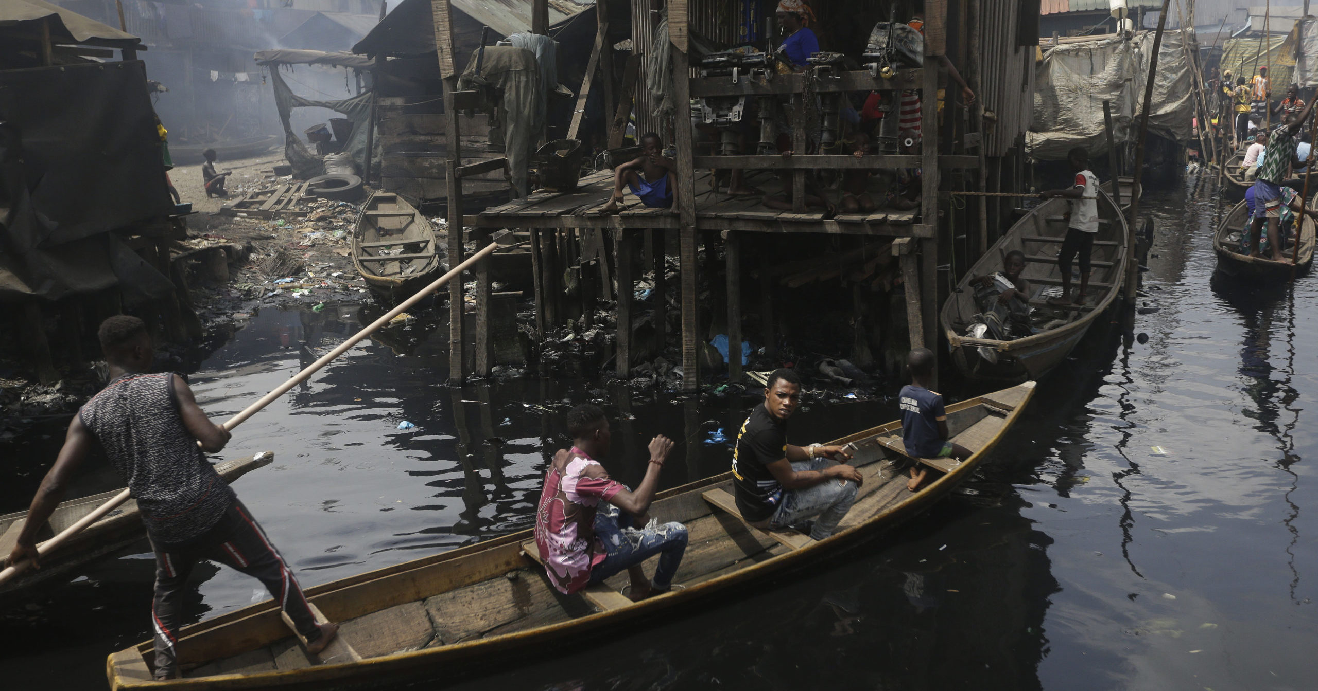 In this March 21, 2020, file photo, people travel by canoe during a coronavirus lockdown in the floating slum of Makoko in Lagos, Nigeria.