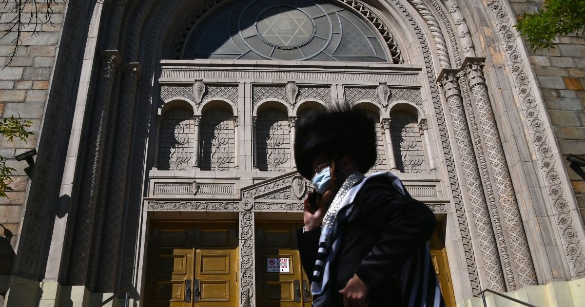 A Hasidic Jew walks past a closed synagogue in the Borough Park section of Brooklyn, New York City, on Oct. 9, 2020.
