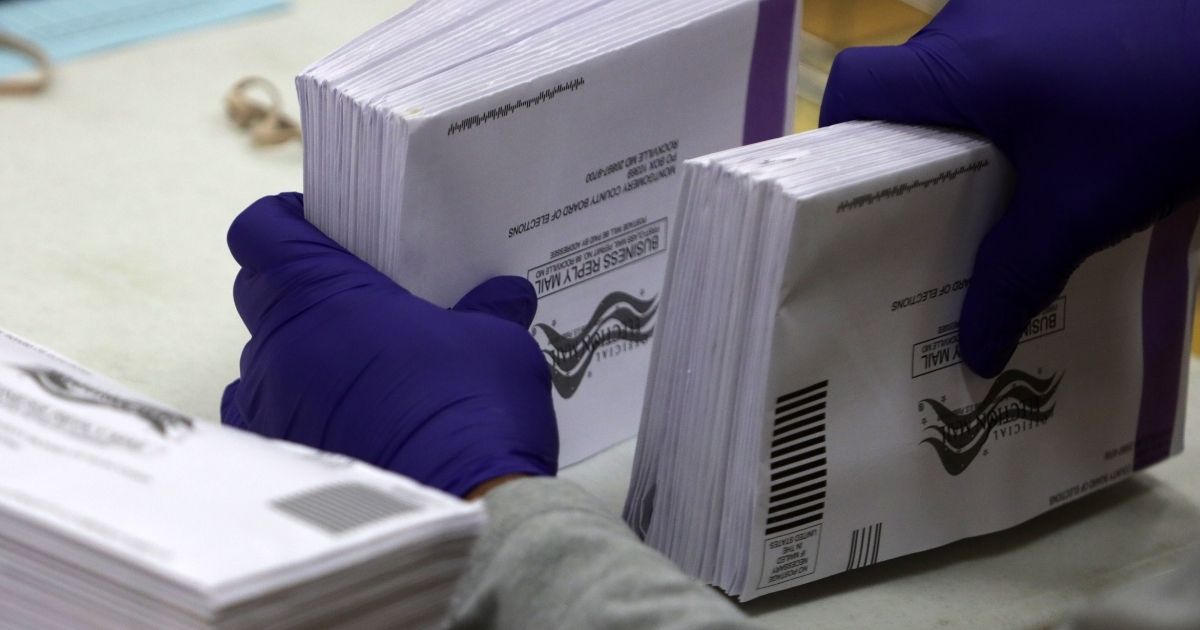 An election worker prepares early mail-in ballots to be scanned on Oct. 20, 2020, in Germantown, Maryland.