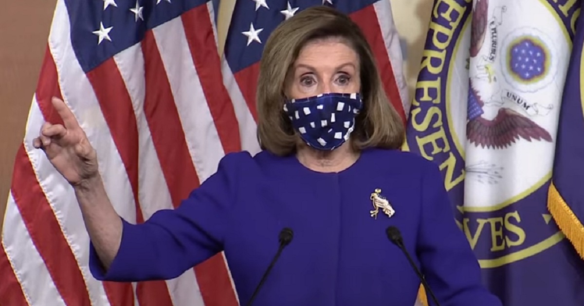 House Speaker Nancy Pelosi addresses the media with a mask on Thursday at the Capitol.